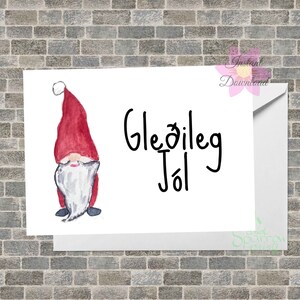 Puede incluir: Una tarjeta de felicitación blanca con una ilustración en acuarela de un gnomo con un gorro rojo y barba blanca. La tarjeta tiene el texto "Gleðileg Jól" en escritura negra y está dentro de un sobre blanco.