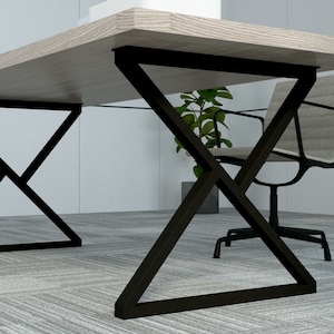 May include: A wooden desk with a black metal X-shaped base. The desk is in a modern office setting with a chair and a plant.