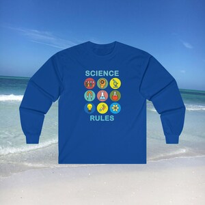 Op de afbeelding: Een koninklijkblauw longsleeve t-shirt met de tekst "SCIENCE RULES" in lichtblauw. Het shirt heeft een afbeelding van negen kleurrijke wetenschappelijke iconen.