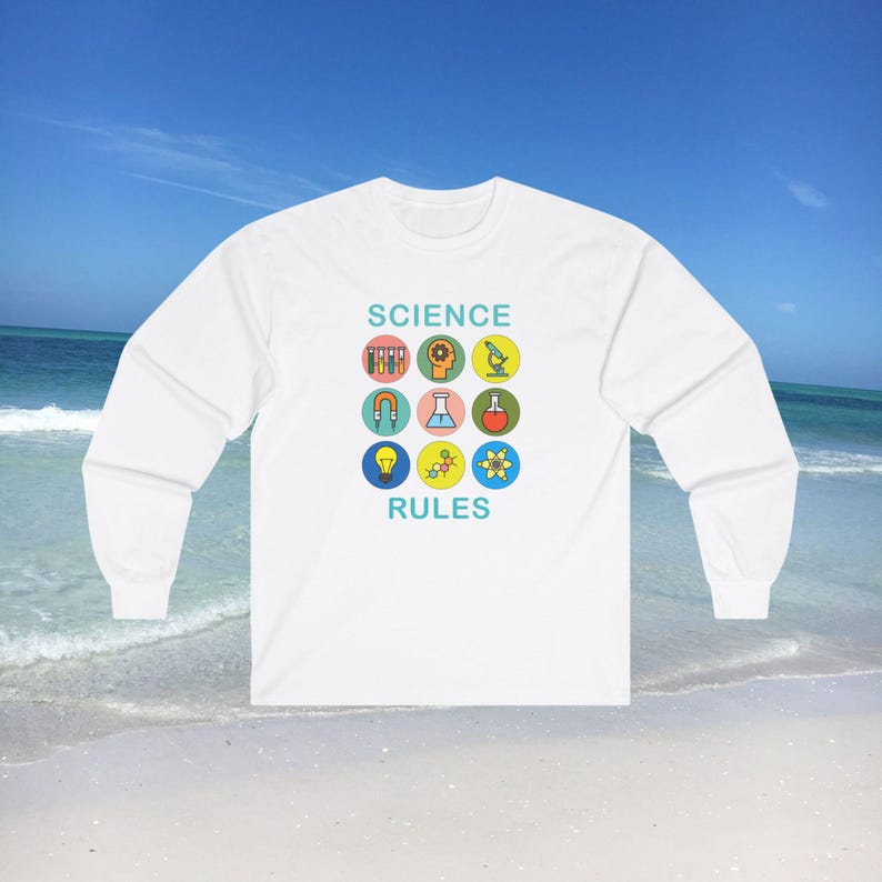 Op de afbeelding: Witte longsleeve t-shirt met de tekst "SCIENCE RULES" in blauw en een afbeelding van negen wetenschappelijke iconen in kleurrijke cirkels.