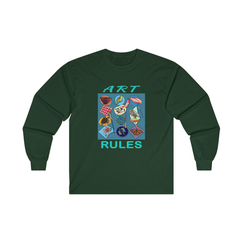 Pu&ograve; includere: Una maglietta a maniche lunghe verde scuro con una grafica quadrata blu che dice "ART RULES" in testo turchese. La grafica presenta una variet&agrave; di immagini colorate, tra cui una tavolozza di colori, un uccello e una farfalla.