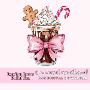 K&ouml;nnte beinhalten: Eine Aquarell-Illustration eines Schokoladengetr&auml;nks mit Schlagsahne, Streuseln und einem Zuckerstangen. Ein Lebkuchen sitzt am Rand des Glases. Eine rosafarbene Schleife ist um das Glas gebunden. Der Text "Design Barn Print Co." befindet sich am unteren Rand des Bildes.