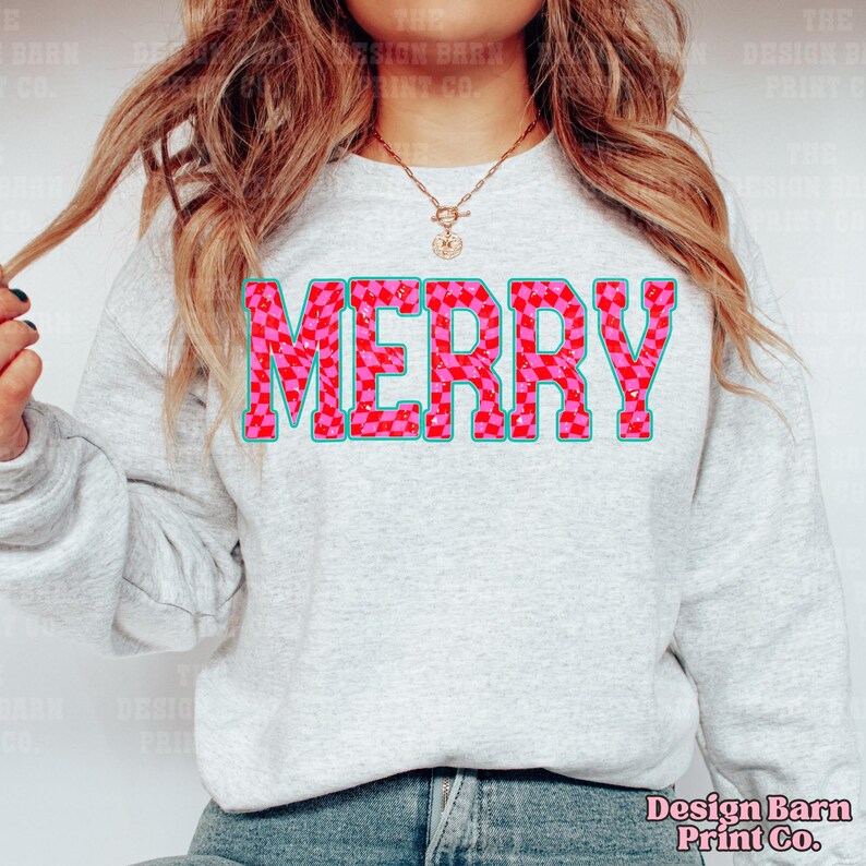 May include: A gray sweatshirt with the word "MERRY" printed in large, bold letters. The letters are pink and white checkered with a blue outline.