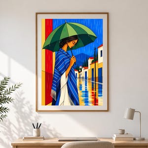 May include: A framed wall art print depicting a person standing under a green umbrella during a rainstorm. The scene features a blue and white striped shawl, a vibrant yellow and red background, and a street with white buildings and blue reflections.