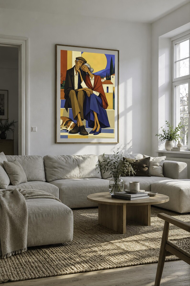 May include: A framed wall art print depicting an elderly couple sitting together on steps with a dog resting at their feet. The illustration features a warm colour palette with yellow, blue, and brown tones, showcasing a Mediterranean landscape.