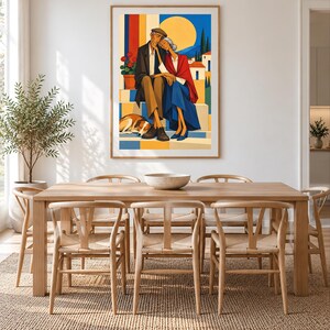 May include: A framed wall art print featuring a colourful illustration of an elderly couple sitting together on steps with a dog resting at their feet. The scene includes a bright yellow sun, blue sky, and white buildings in the background, rendered in a flat, graphic style with bold blocks of colour.