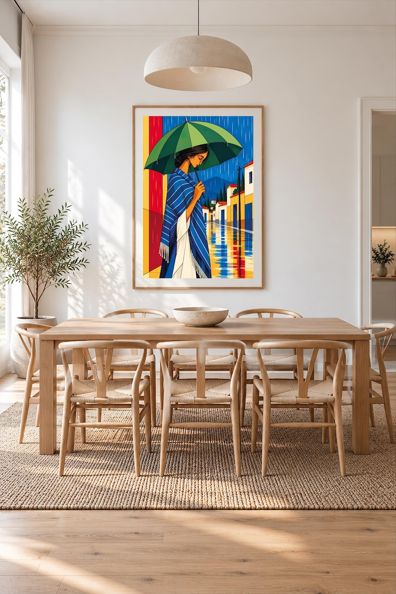 May include: A framed vertical art print depicting a person standing under a large green umbrella during a rainstorm. The person wears a blue and white striped shawl over a white garment. The background shows a street with buildings and reflections.