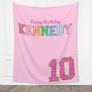 Może przedstawiać: Różowe tło urodzinowe z tekstem "Happy Birthday KENNEDY" w kolorach tęczy z akcentami złotego brokatu. Liczba "10" jest różowa z akcentami złotego brokatu.