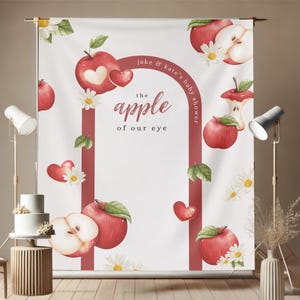 Puede incluir: Un tel&oacute;n de fondo blanco con un tema de baby shower, con manzanas rojas, margaritas y corazones. El texto dice "the apple of our eye" y "jake & kate's baby shower". El dise&ntilde;o incluye un arco rojo y hojas verdes.