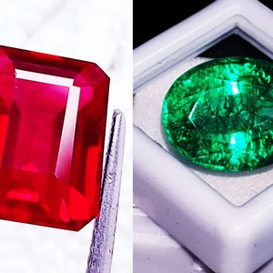 Könnte beinhalten: Ein rechteckig facettierter roter Edelstein, der mit einer Metallpinzette gehalten wird, neben einem oval facettierten grünen Edelstein mit inneren Einschlüssen, der in einem kleinen quadratischen weißen Kunststoffbehälter liegt.