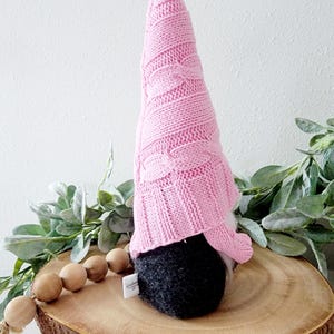 Gnome shown with side view to shiw a tag seen in the back seam.