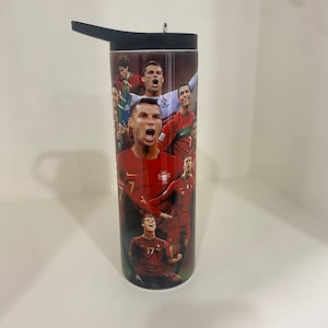 May include: A black and red stainless steel tumbler with a graphic of Portuguese soccer players, including Cristiano Ronaldo. The tumbler has a black lid with a straw.