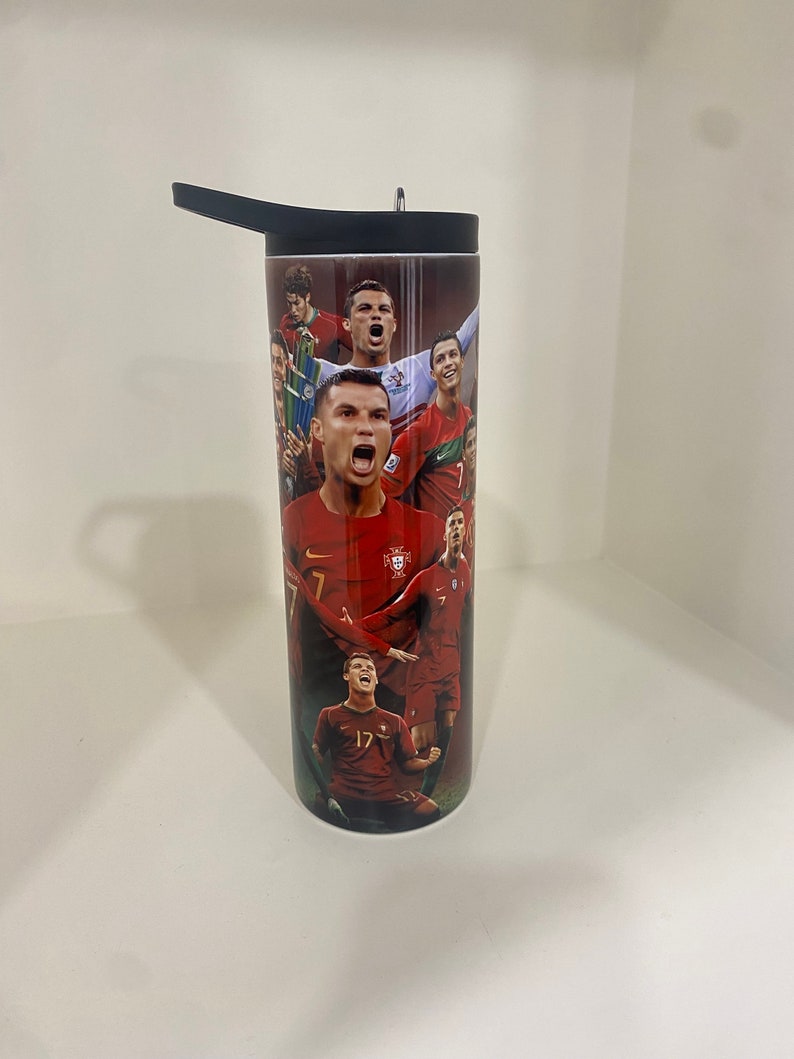 May include: A black and red stainless steel tumbler with a graphic of Portuguese soccer players, including Cristiano Ronaldo. The tumbler has a black lid with a straw.