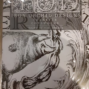 Puede incluir: Un paquete de hojas de transferencia Iron Orchid Designs con una ilustración en blanco y negro de un cerdo y adornos decorativos. El paquete contiene ocho hojas de 30,5 cm x 40,6 cm. El nombre de la marca y los detalles del producto están impresos en gris y negro.