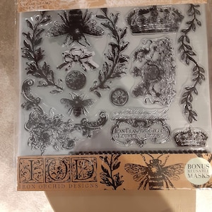 Puede incluir: Juego de sellos transparentes con diseños de abejas y coronas, con el texto "IRON ORCHID DESIGNS DECOR STAMP QUEEN BEE" y "JEAN FRANCOIS-GILLET, ECUYER 1778". Incluye máscaras reutilizables de bonificación. Ideal para manualidades y álbumes de recortes.