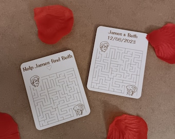 Könnte beinhalten: Zwei weiße Holzkarten mit jeweils einem Labyrinth. Die obere Karte zeigt "James & Beth 12/03/2023". Die untere Karte zeigt "Help James find Beth" mit einem Herzsymbol.