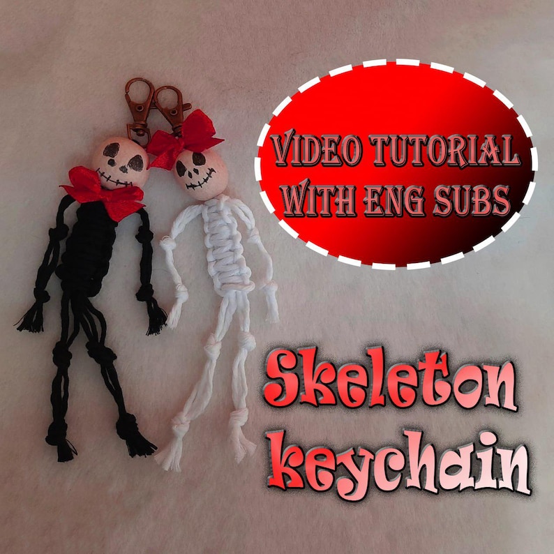 May include: Two skeleton keychains made of knotted cord, one black and one white, each featuring a wooden bead head with a painted face and a red fabric bow. The image includes text stating VIDEO TUTORIAL WITH ENG SUBS and Skeleton keychain.