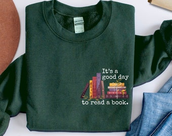 May include: A dark green sweatshirt with a stack of books and the text "It's a good day to read a book." printed on the front.