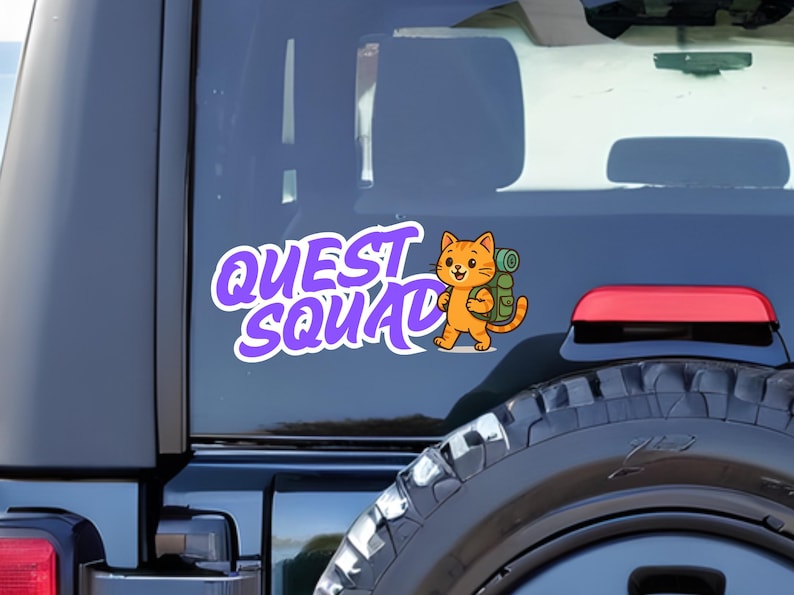 May include: A white and purple "Quest Squad" sticker featuring a cartoon orange cat with a green backpack. The sticker is affixed to the rear window of a vehicle, with the tire and taillight visible.