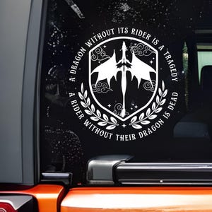 May include: White vinyl decal featuring a dragon design within a shield shape, surrounded by a laurel wreath. The text reads, "A dragon without its rider is a tragedy. A rider without their dragon is dead."