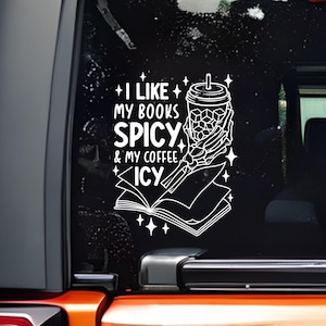 May include: White decal with the text "I like my books spicy & my coffee icy." The design includes a skeleton hand holding a coffee cup and a book. The decal is on a black background.