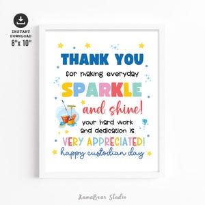 May include: A framed print with the text "THANK YOU" in blue, "SPARKLE" in colourful letters, and "and shine!" in red. The print includes a cleaning supplies graphic and is 20.32cm x 25.4cm in size.