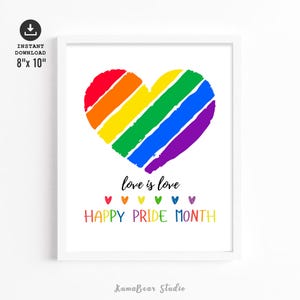 May include: A framed print featuring a rainbow heart design. The heart is made up of red, orange, yellow, green, blue, and purple stripes. Text reads "love is love" and "HAPPY PRIDE MONTH". The print measures 20.3 cm x 25.4 cm.