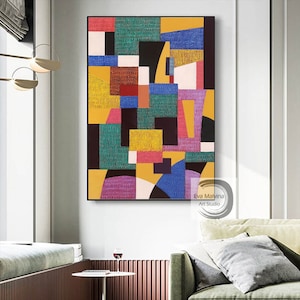 May include: Abstract geometric painting with a colorful design of squares, rectangles, and circles in shades of yellow, green, blue, pink, red, and black. The painting is signed "Eva Malvina Art Studio".