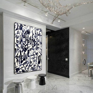 K&ouml;nnte beinhalten: Ein abstraktes Schwarzwei&szlig;bild mit den Worten "Warm", "Hot", "Love" und "Peace", die in Graffiti-Stil geschrieben sind. Das Bild h&auml;ngt an einer wei&szlig;en Wand in einem modernen Interieur.