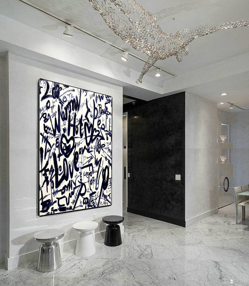 K&ouml;nnte beinhalten: Ein abstraktes Schwarzwei&szlig;bild mit den Worten "Warm", "Hot", "Love" und "Peace", die in Graffiti-Stil geschrieben sind. Das Bild h&auml;ngt an einer wei&szlig;en Wand in einem modernen Interieur.