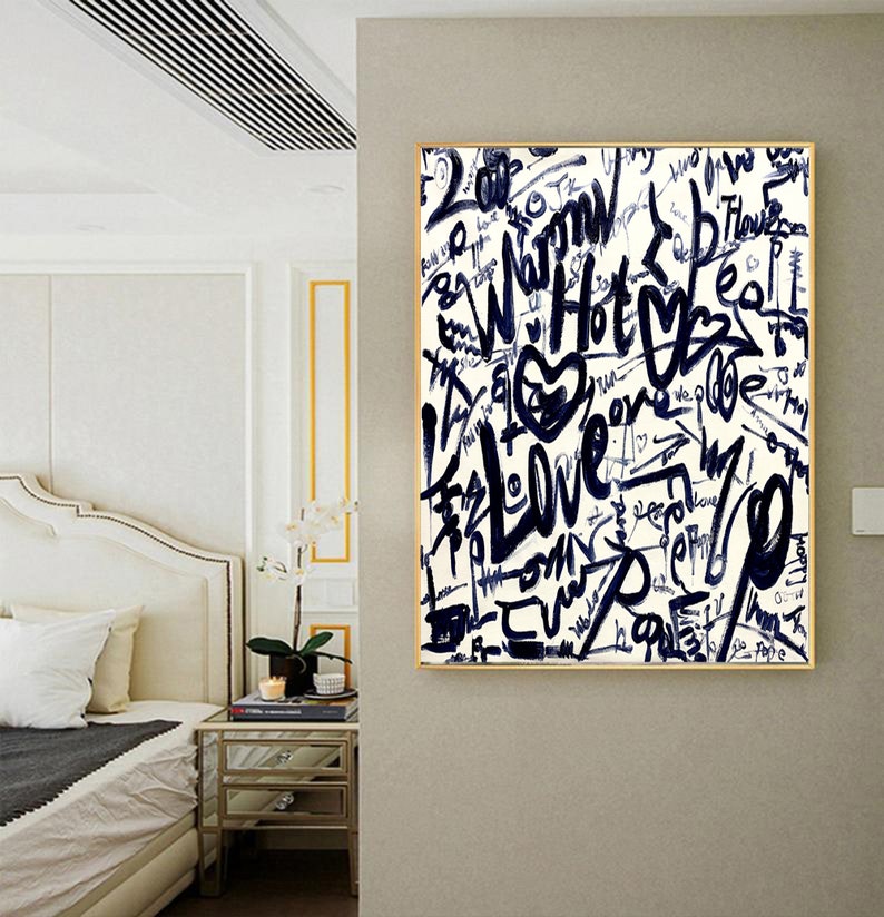 K&ouml;nnte beinhalten: Eine wei&szlig;e Leinwand mit goldenem Rahmen zeigt ein abstraktes Design in Schwarzwei&szlig; mit den W&ouml;rtern "Love", "Hot" und "Warm", die in Graffiti-Stil geschrieben sind.