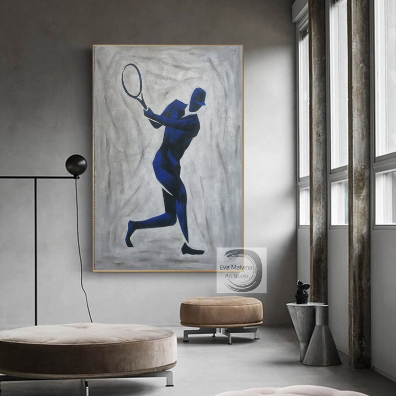 K&ouml;nnte beinhalten: Abstrakte Malerei eines Tennisspielers in blauer Silhouette auf grauem Hintergrund. Das Gem&auml;lde ist gerahmt und h&auml;ngt an einer Wand in einem modernen Interieur.