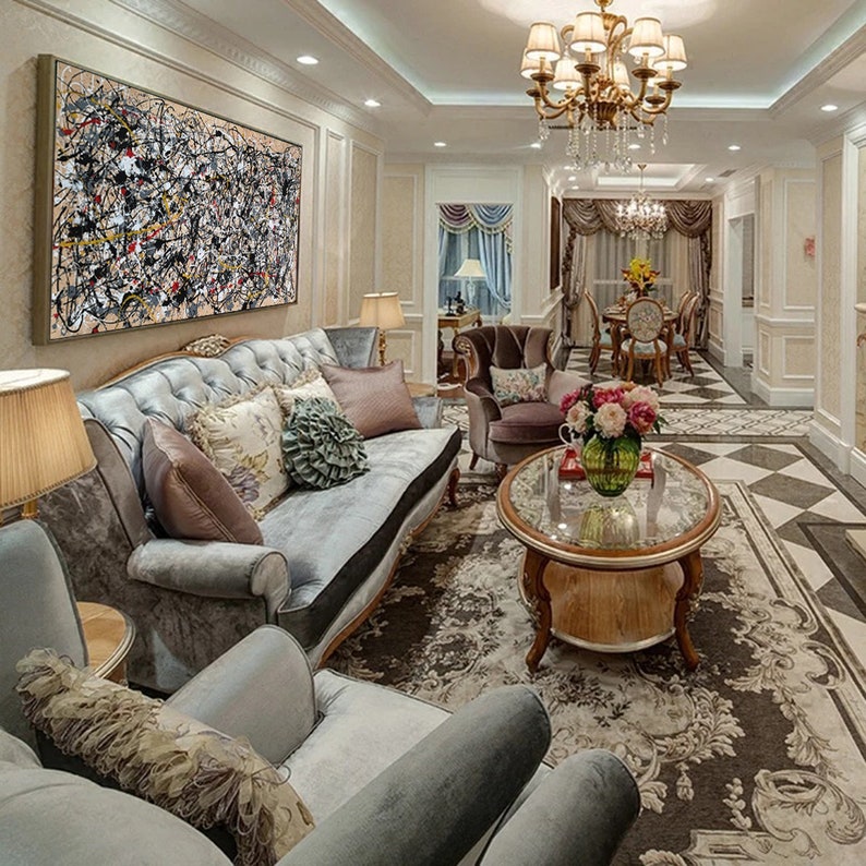 May include: A living room with a large abstract painting on the wall, a gray sofa with pillows, a coffee table with a vase of flowers, and a rug on the floor.