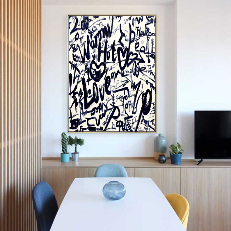 K&ouml;nnte beinhalten: Ein Schwarz-Wei&szlig;-Abstrakt-Kunstdruck mit goldenem Rahmen. Der Druck zeigt eine Vielzahl von W&ouml;rtern und Phrasen, die in einer fetten, Graffiti-Schrift geschrieben sind, darunter "Love", "Hot" und "Dream".