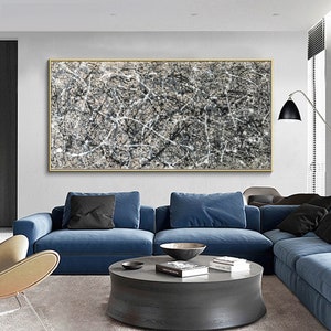 May include: Abstract art painting with black and white lines on a beige background. The painting is framed in a gold frame and is hanging on a wall above a blue sofa.