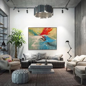May include: A living room with a grey sofa, two armchairs, a coffee table, and a large abstract painting on the wall. The painting features splashes of red, blue, yellow, and white paint.