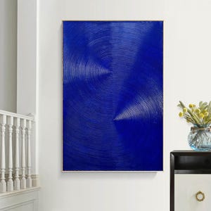 May include: Abstract painting with a blue background and concentric circles in a white and light blue pattern.