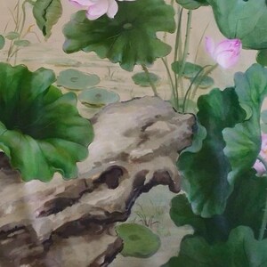 May include: A watercolor painting of a lotus flower with green leaves and a large rock in the foreground. The painting is done in a traditional Chinese style.