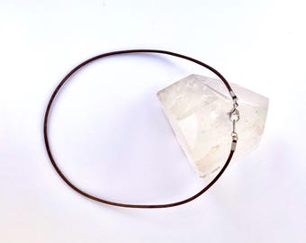 Peut inclure: Un collier en cordon de cuir marron avec un fermoir argenté.
