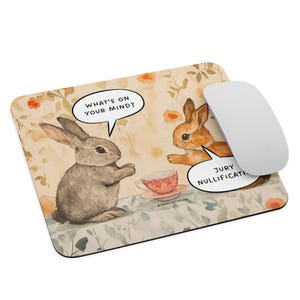 May include: A mouse pad with a cartoon illustration of two rabbits having tea. One rabbit is asking the other, "What's on your mind?" The other rabbit is responding with a speech bubble that says "Jury Nullification".