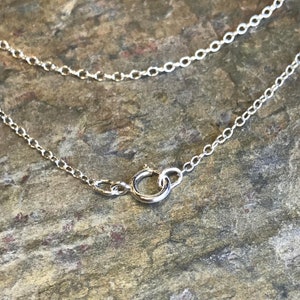 May include: Close-up of a silver chain necklace with a lobster clasp.