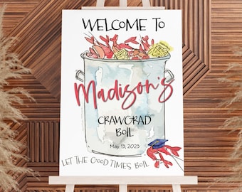 May include: A welcome sign on an easel with the text "Welcome to Madison's Crawgrad Boil May 13, 2023." The sign features a watercolor illustration of a pot of crawfish and the phrase "Let the good times boil."