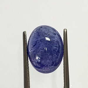 May include: A purple oval cabochon gemstone held by tweezers.