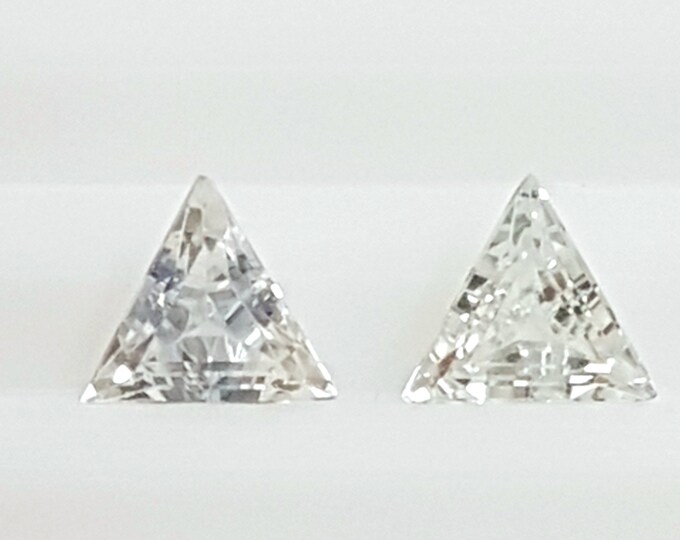 Couple of natural white sapphire, trillion/triangle mm.4,42x4,42x4,42, h.mm.2,32, cts.0,65
