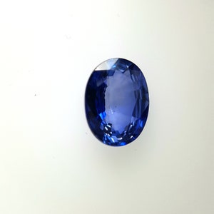 May include: A deep blue sapphire gemstone with a round cut and a faceted surface.