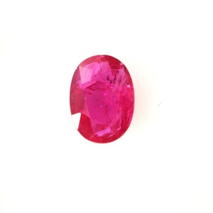 Puede incluir: Una gema ovalada de color rosa vibrante con un corte facetado.