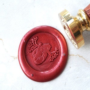 May include: A red wax seal with a detailed anatomical heart design. The seal is made with a traditional wax seal stamp.
