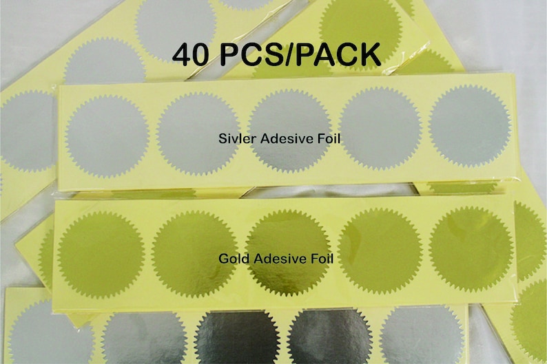 May include: A pack of 40 self-adhesive gold and silver foil seals. The seals are round and have a scalloped edge. The pack includes two sheets of seals, one sheet with gold seals and one sheet with silver seals. The text "40 PCS/PACK" is printed on the top of the pack. The text "Siviver Adesive Foil" is printed on the sheet of silver seals. The text "Gold Adesive Foil" is printed on the sheet of gold seals.