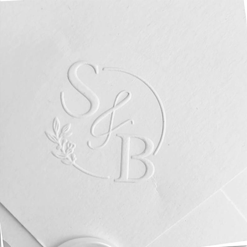 May include: White embossed paper with a circle containing the letters "S & B" and a small floral design.