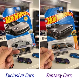 May include: Two Hot Wheels toy cars in their original packaging. One is a silver Porsche 911 Carrera T, and the other is a gray Drift'n Break. The packaging is blue with the Hot Wheels logo and text. The image also includes the text "Exclusive Cars" and "Fantasy Cars".
